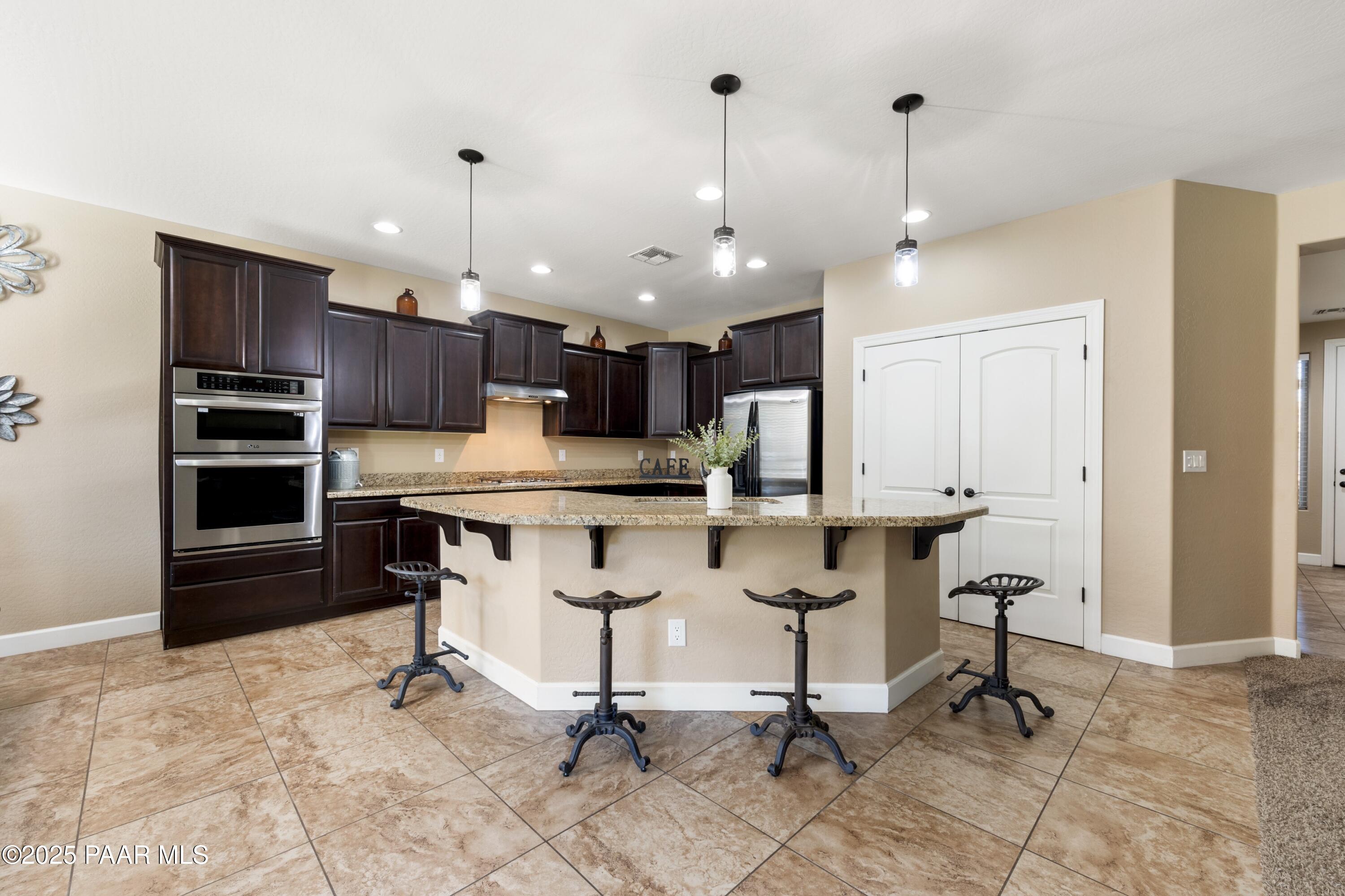 1200 Rusty Nail Road Prescott Valley, AZ 86314 - Photo 7 of 32 a view of kitchen with kitchen island stainless steel appliances a stove a table and chairs