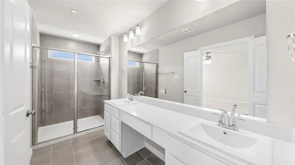a bathroom with a shower sink and mirror