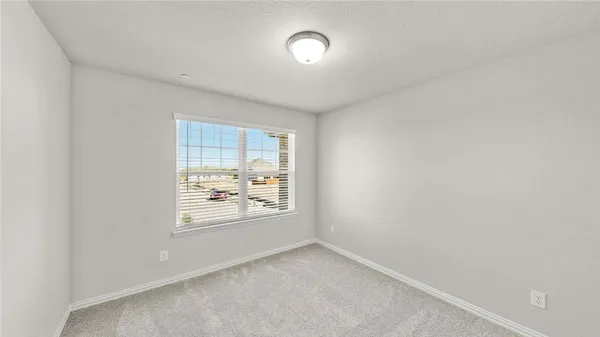 an empty room with windows and mirror