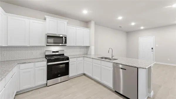 a kitchen with stainless steel appliances granite countertop a sink and a stove