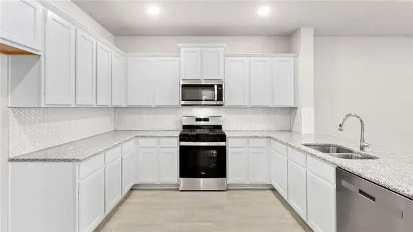 a kitchen with stainless steel appliances granite countertop a stove and a sink