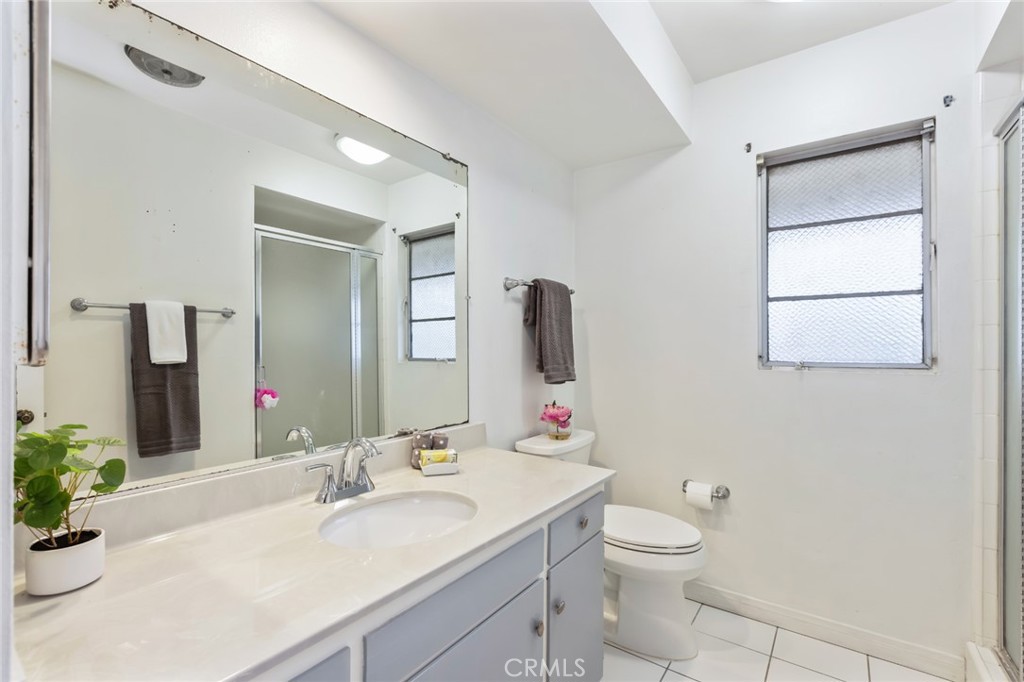 23026 Nadine Circle, Unit B Torrance, CA 90505 - Photo 23 of 56 a bathroom with a granite countertop toilet a sink and a mirror