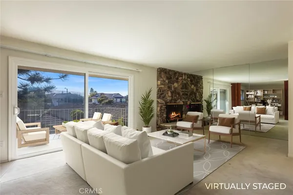 a view of a big room with large windows and fireplace