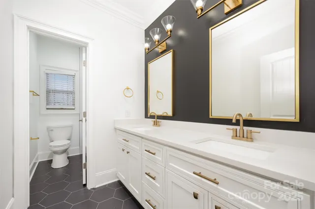 a bathroom with a sink a toilet and a mirror