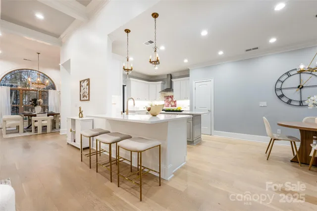a kitchen with kitchen island stainless steel appliances a table and chairs in it