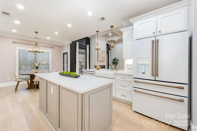 a kitchen with white cabinets and refrigerator