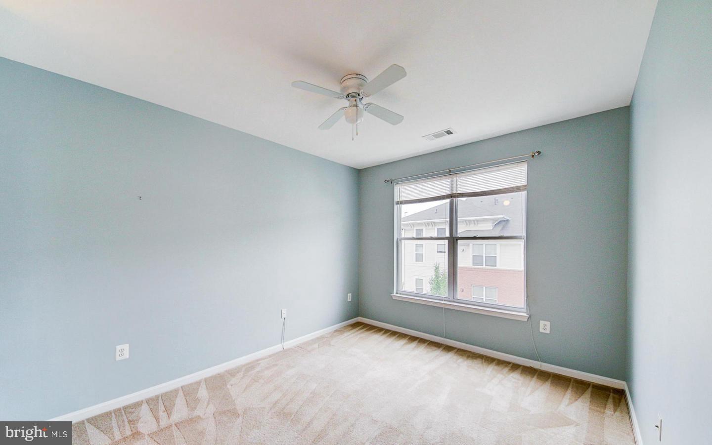9480 Virginia Center Boulevard, Unit 420 Vienna, VA 22181 - Photo 2 of 17 an empty room with chandelier fan and windows