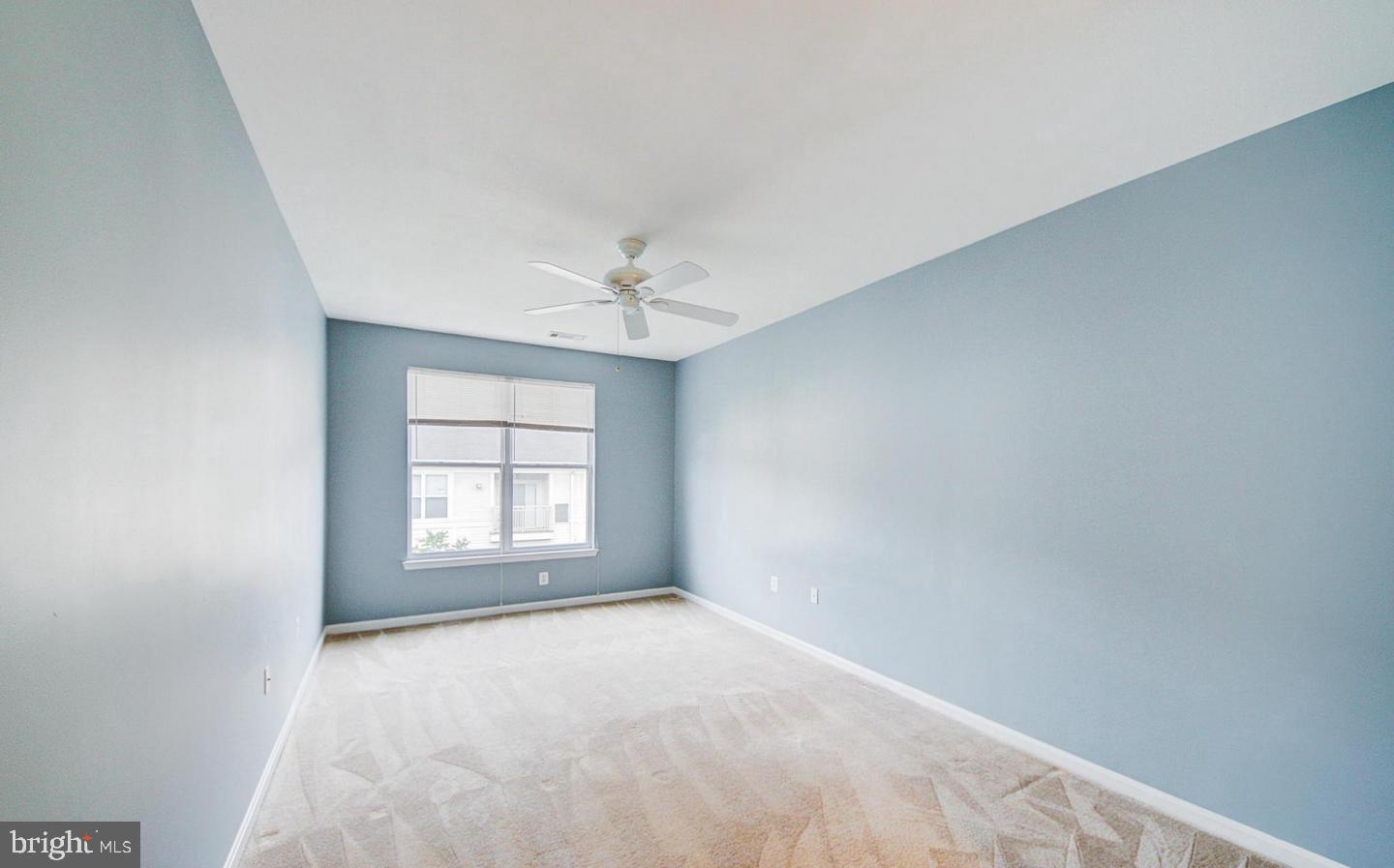 9480 Virginia Center Boulevard, Unit 420 Vienna, VA 22181 - Photo 6 of 17 an empty room with windows and chandelier fan