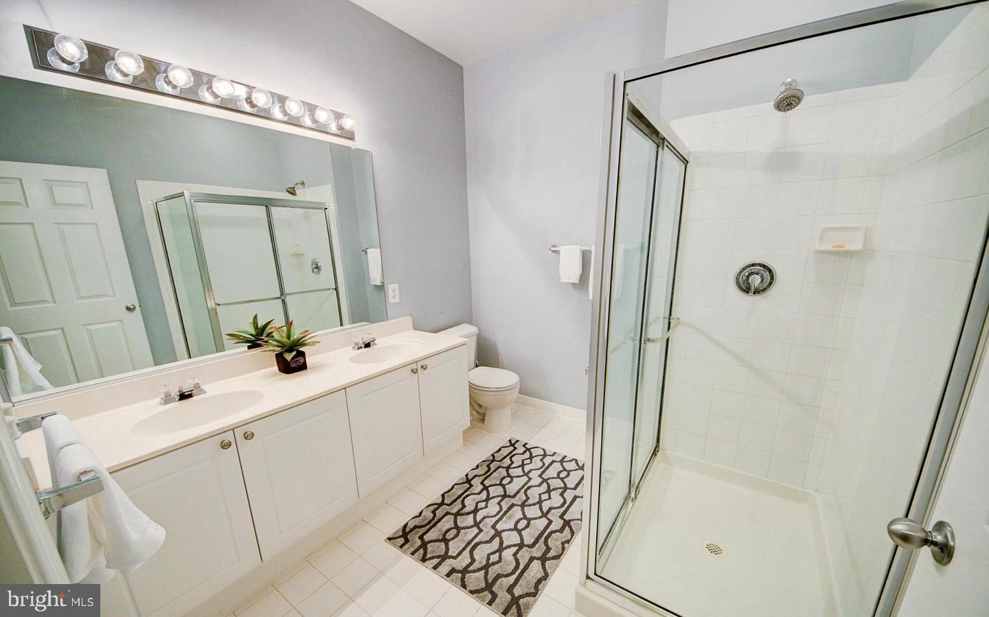 9480 Virginia Center Boulevard, Unit 420 Vienna, VA 22181 - Photo 10 of 17 a bathroom with a sink a toilet a mirror and shower