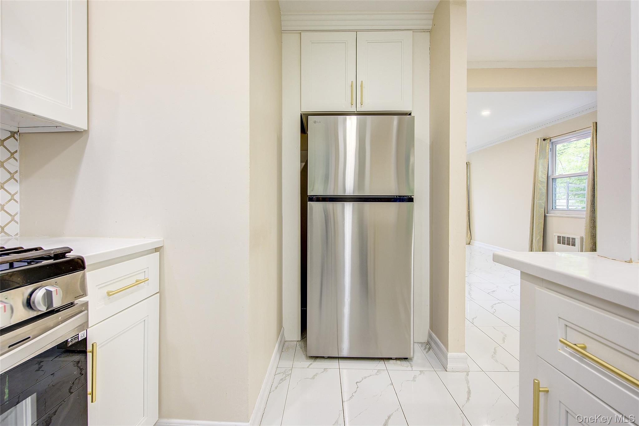 164-38 76th Road Queens, NY 11366 - Photo 12 of 44 a view of a kitchen with refrigerator and wooden floor