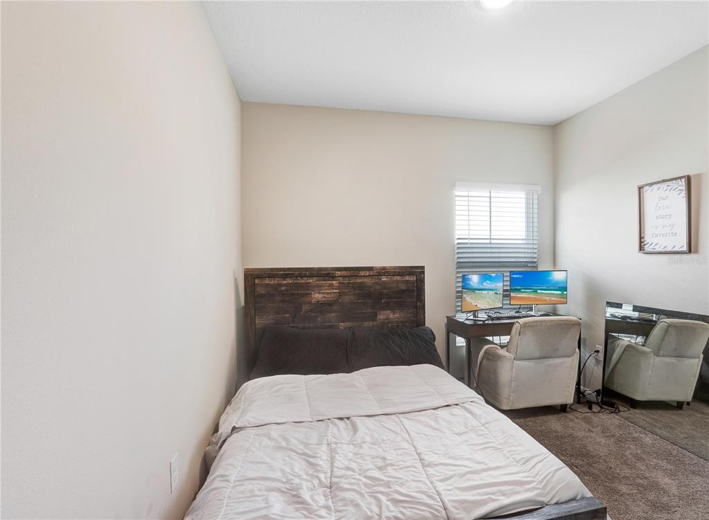 7704 Twinleaf Ter Way Parrish, FL 34219 - Photo 12 of 31 a bedroom with a bed and a couch