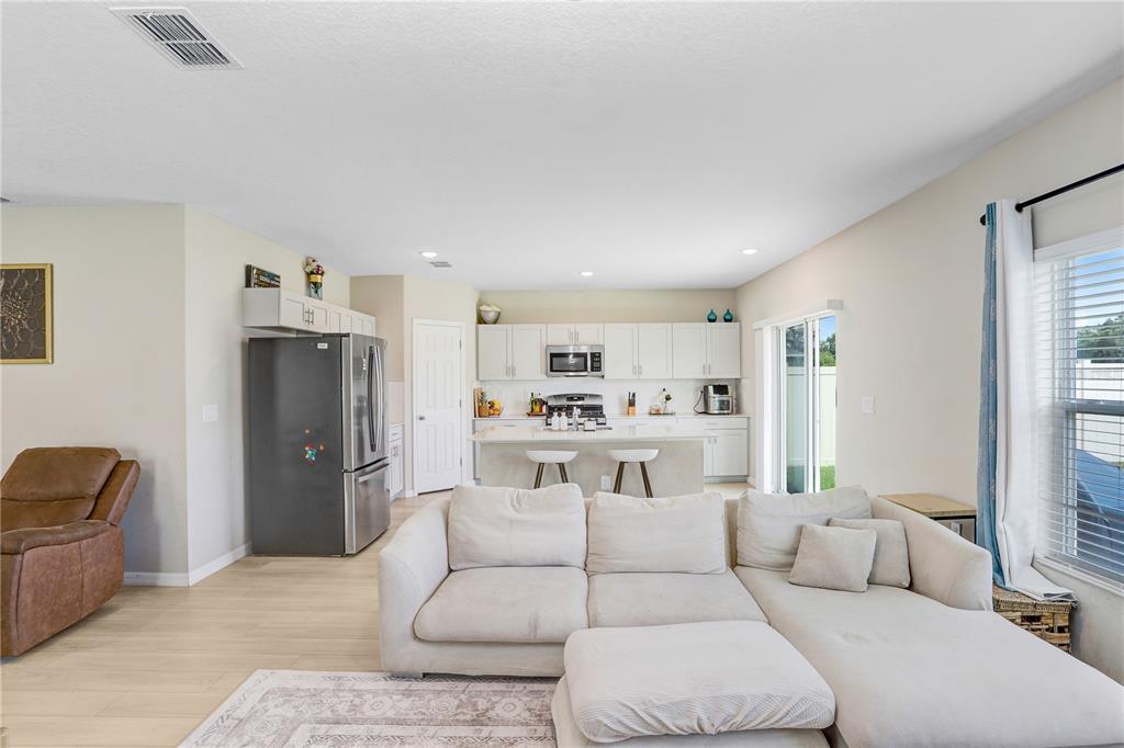 7704 Twinleaf Ter Way Parrish, FL 34219 - Photo 18 of 31 a living room with furniture and a refrigerator
