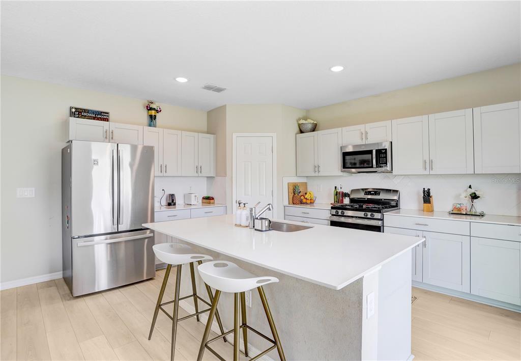 7704 Twinleaf Ter Way Parrish, FL 34219 - Photo 7 of 31 a kitchen with stainless steel appliances a refrigerator stove microwave and cabinets