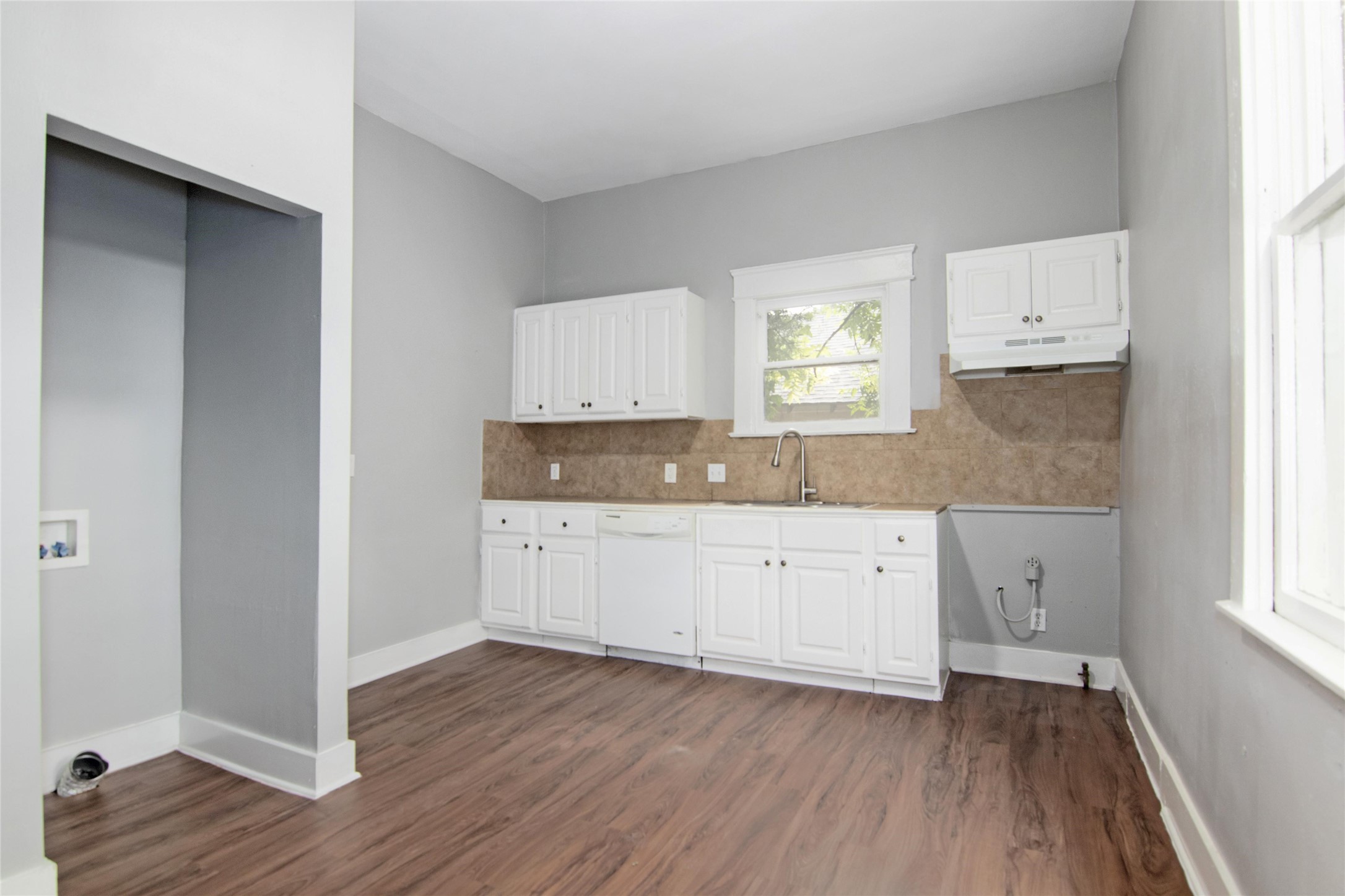 3220 Melbourne Street Houston, TX 77026 - Photo 13 of 23 a kitchen with cabinets wooden floor and a window