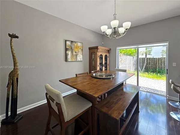 a view of a dining room with furniture a chandelier and wooden floor