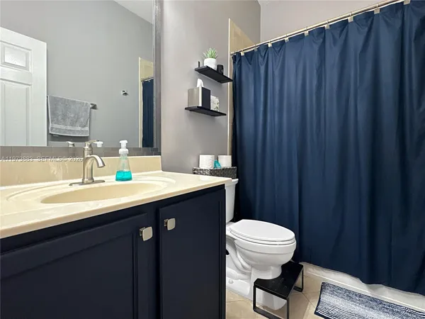 a bathroom with a sink a toilet a light fixture and mirror