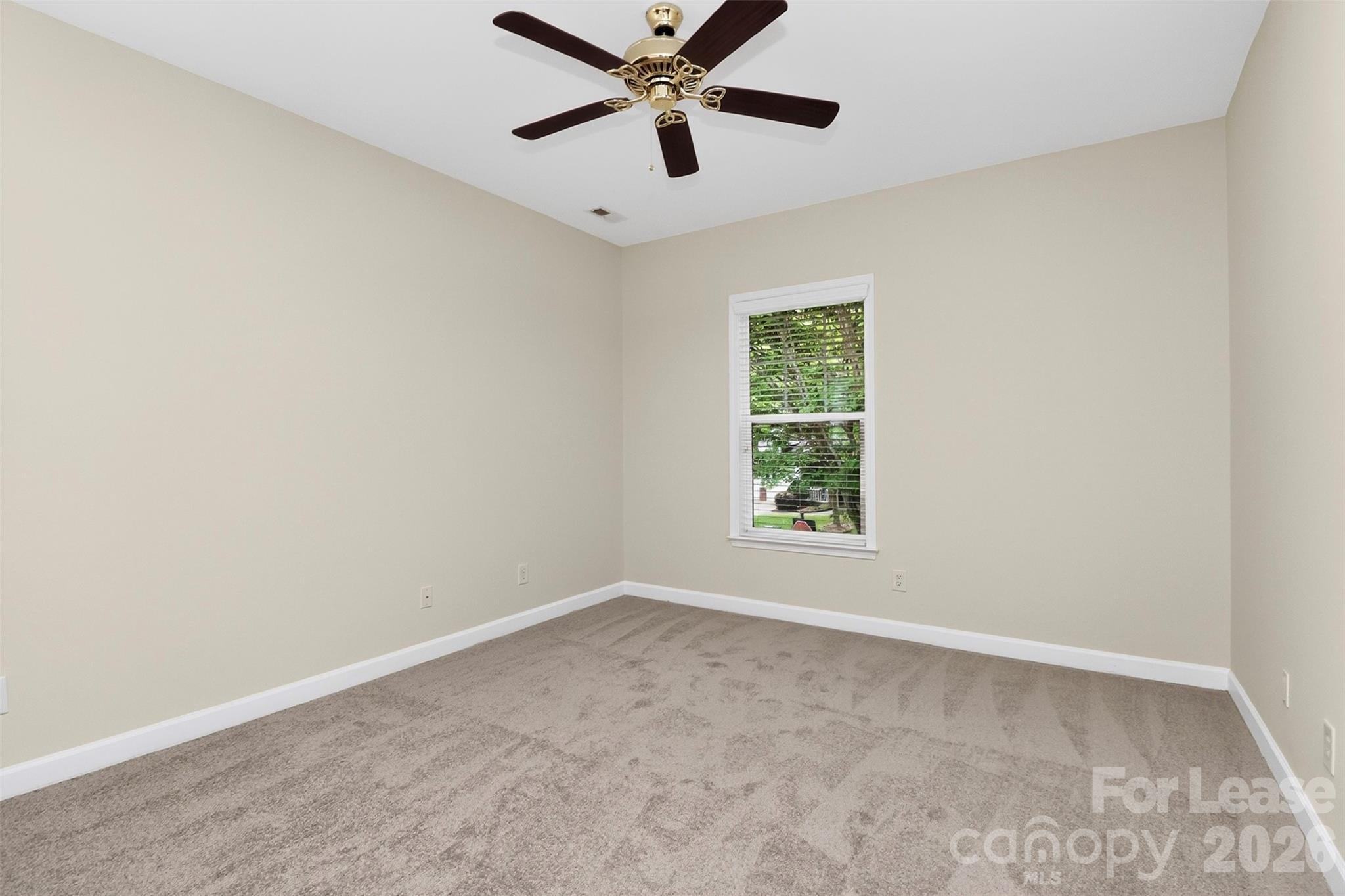 9315 Rosalyn Glen Road Cornelius, NC 28031 - Photo 19 of 35 an empty room with a window and a fan