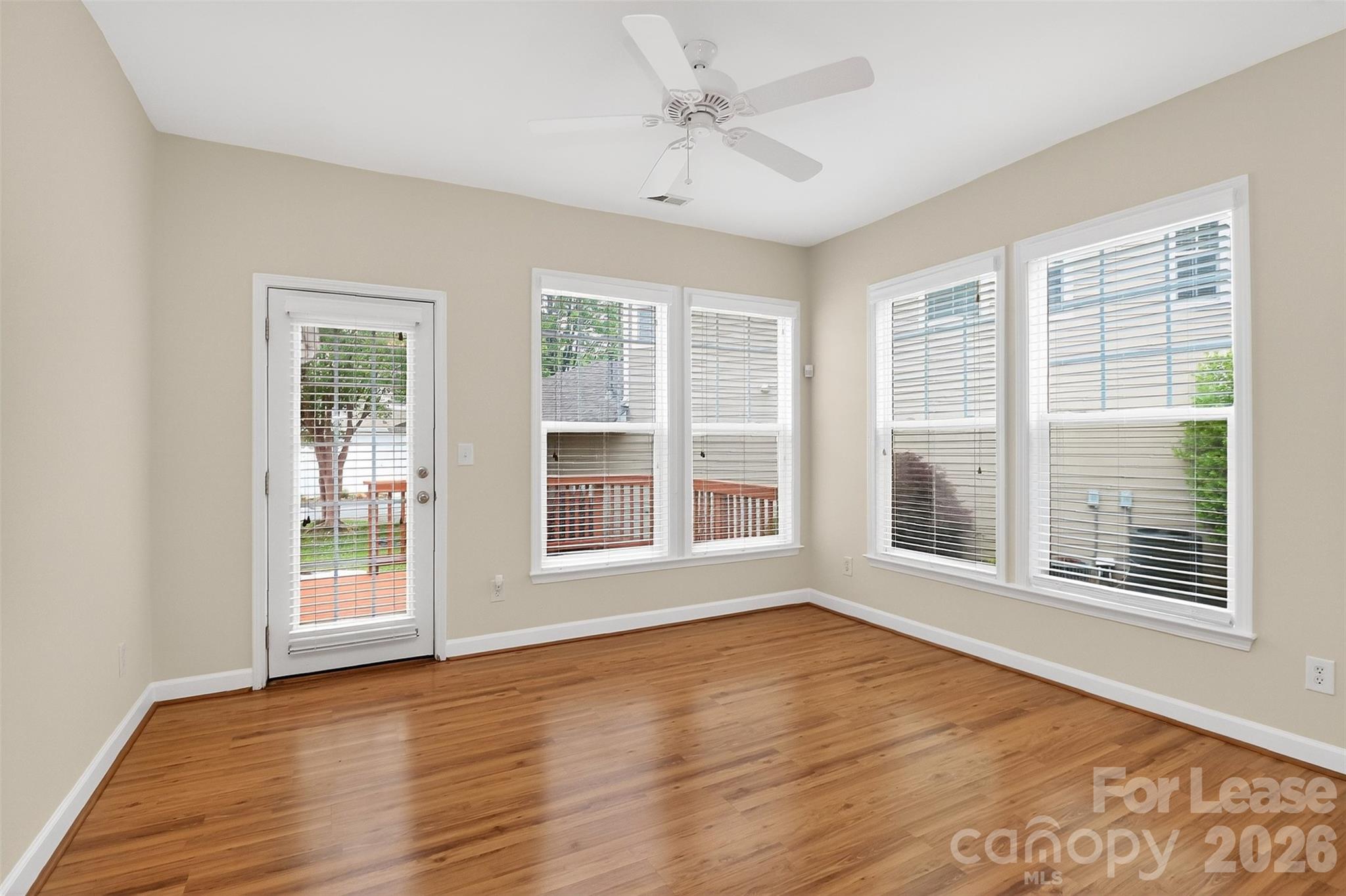 9315 Rosalyn Glen Road Cornelius, NC 28031 - Photo 7 of 35 a view of an empty room with wooden floor and windows