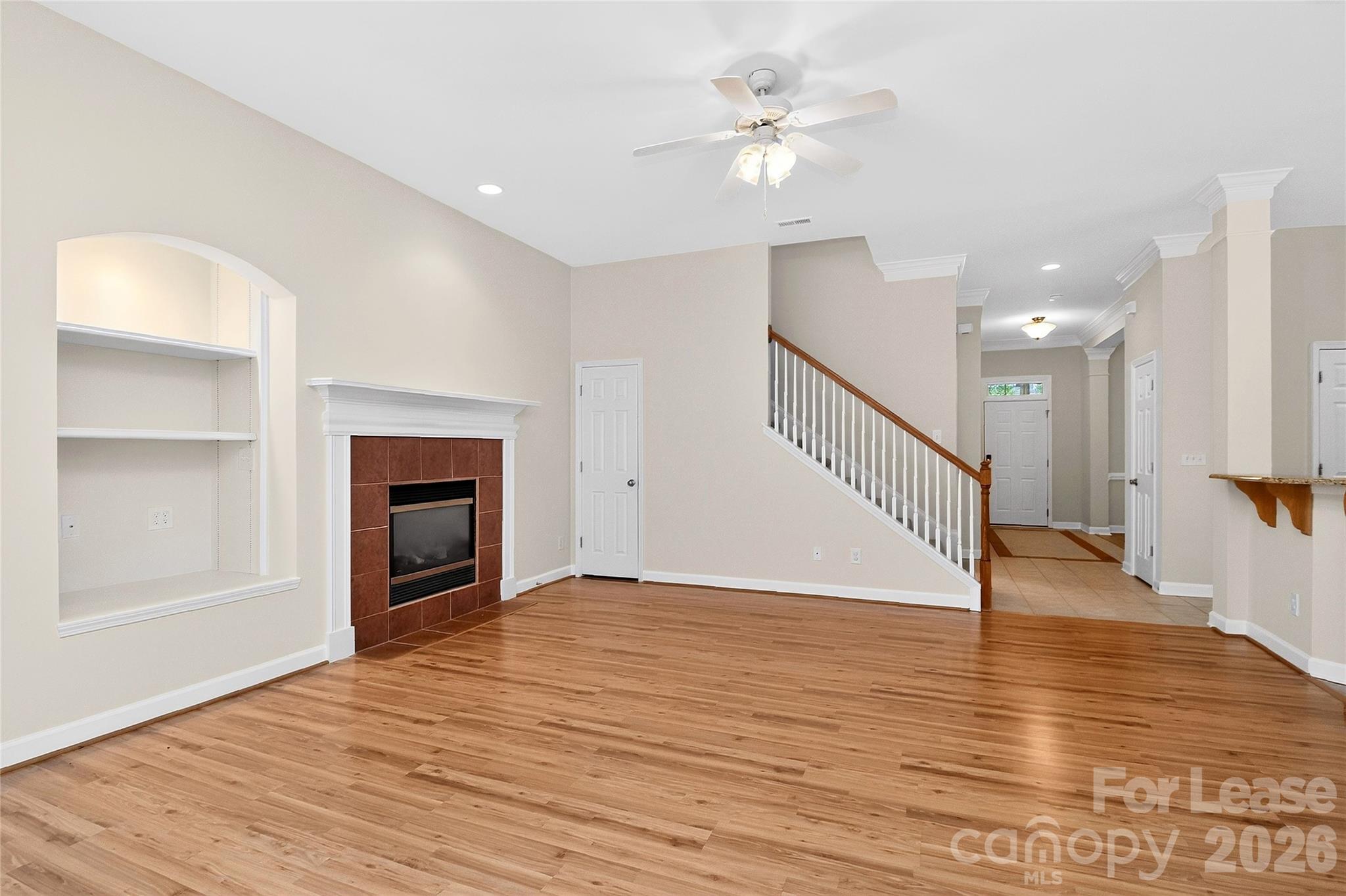 9315 Rosalyn Glen Road Cornelius, NC 28031 - Photo 9 of 35 a view of an empty room with wooden floor and a fireplace