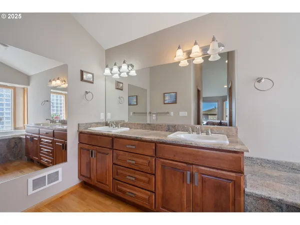 a bathroom with a sink double vanity granite and a mirror