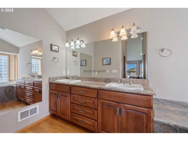 a bathroom with a sink double vanity granite and a mirror