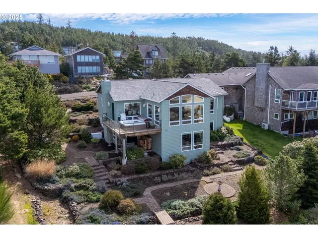 a view of a big house with a big yard plants and large trees