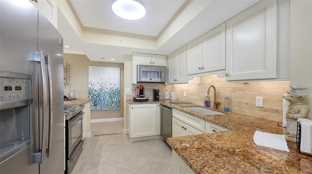 775 Longboat Club Road, Unit 304 Longboat Key, FL 34228 - Photo 11 of 52 a kitchen with a refrigerator and a sink