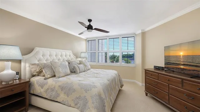 a bedroom with a large bed and ceiling fan