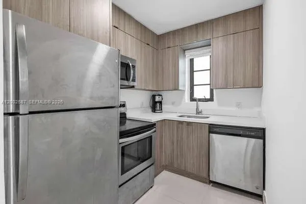 a kitchen with a refrigerator sink and cabinets