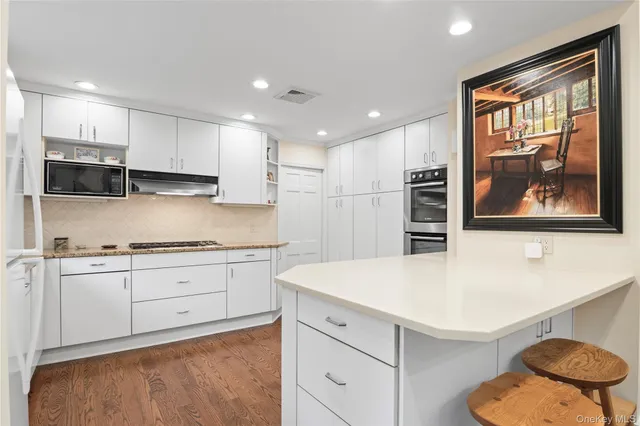a kitchen with stainless steel appliances granite countertop a stove a sink and a refrigerator