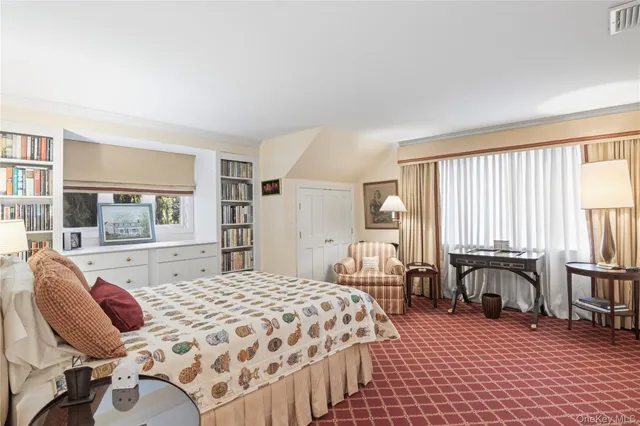 a spacious bedroom with a bed and large windows