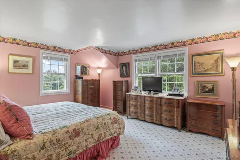 a bedroom with a bed dresser and a window
