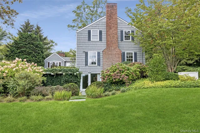 a front view of a house with a yard and potted plants