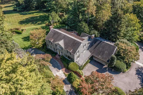 a view of a house with a yard and large trees