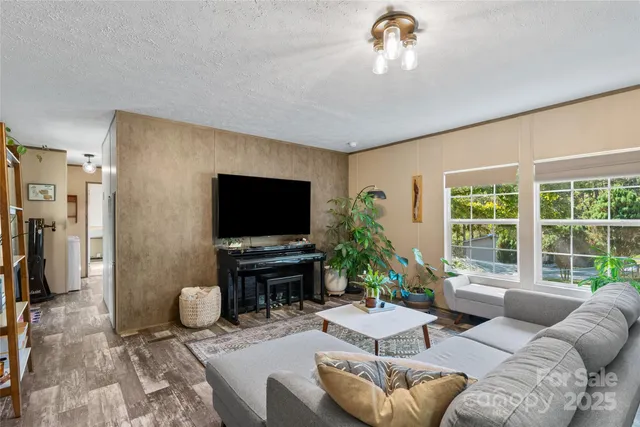 a living room with furniture a flat screen tv and a large window