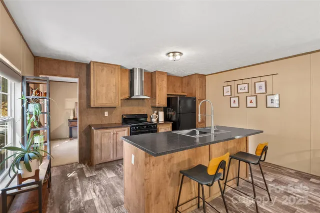 a kitchen with granite countertop a refrigerator stove top oven and sink