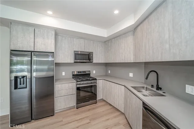 a kitchen with stainless steel appliances a refrigerator a sink a stove a microwave and cabinets