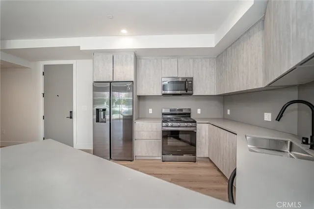 a kitchen with stainless steel appliances a refrigerator stove and sink