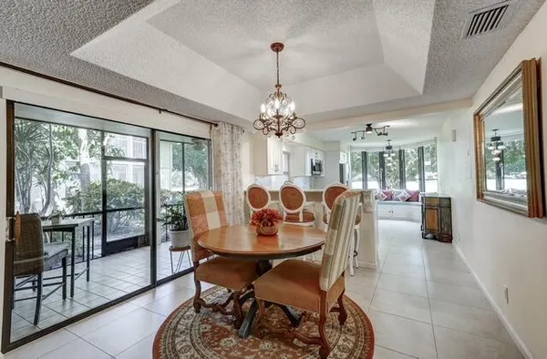 a dining room with furniture a chandelier and window