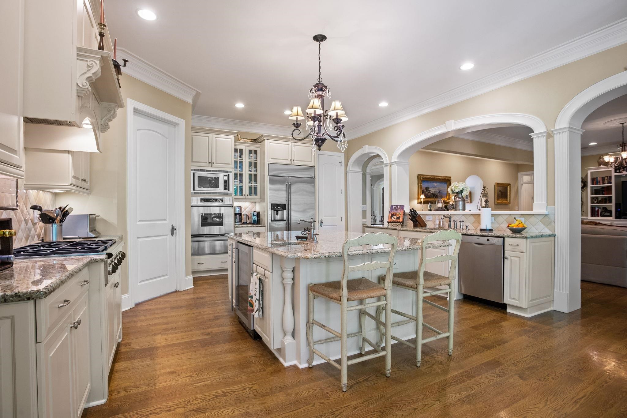 3223 Rain Forrest Way Raleigh, NC 27614 - Photo 17 of 71 a kitchen with stainless steel appliances kitchen island granite countertop a stove a sink dishwasher a refrigerator and white cabinets with wooden floor