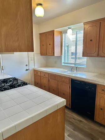 a kitchen with a sink a stove and cabinets
