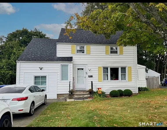 a house that has a big tree in front of it