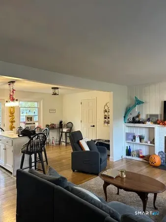 a living room with furniture and view of kitchen