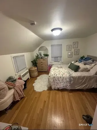 a bedroom with bed and wooden floor