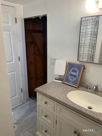 a bathroom with a granite countertop sink toilet and shower