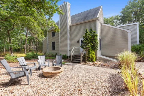a view of a patio with couple of chairs and potted plants