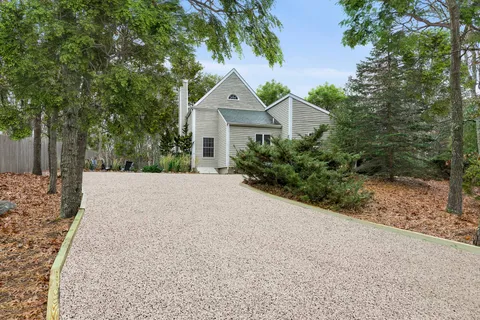 a view of a house with a yard and large trees