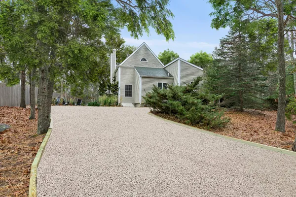 a view of a house with a yard and large trees