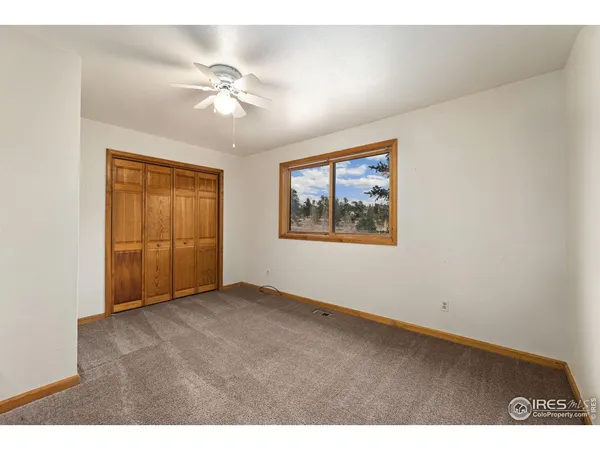 an empty room with fan and windows