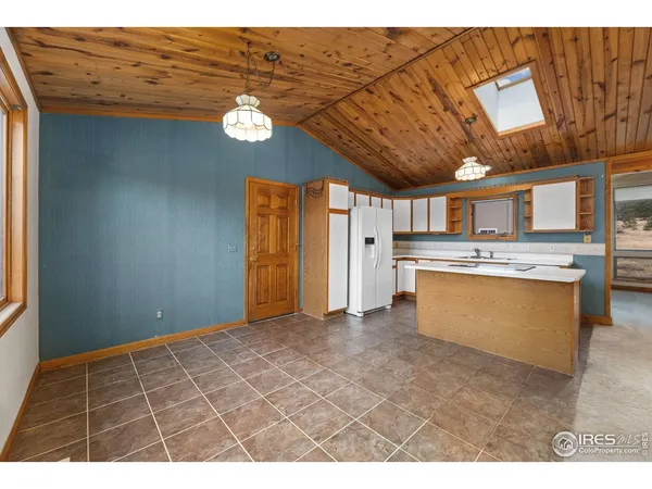 a view of an empty room with a kitchen